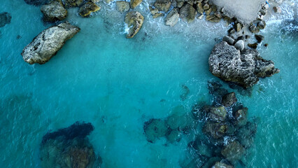 Aerial view of turquoise sea water, transparent seabed, rocky landscape