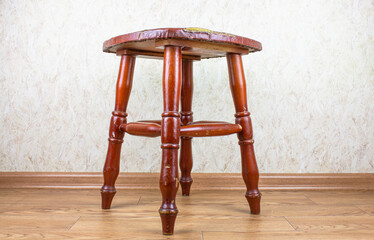 Old wooden stool. A dilapidated stool with a leather seat.