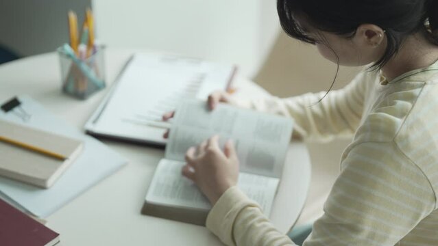 young asian student woman reading a book at college dormitory