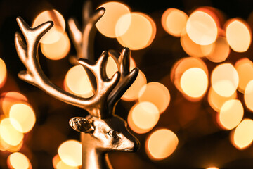 Christmas glowing wallpaper with golden deer and golden bokeh on a black background.Beautiful...