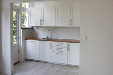Interior of modern kitchen with stylish white furniture