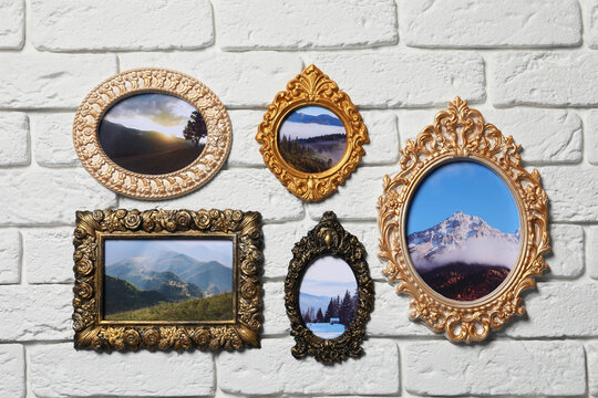 Vintage frames with photos of beautiful landscapes hanging on white brick wall