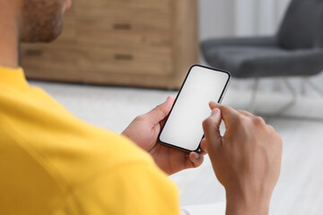 Man using modern mobile phone indoors, closeup