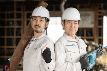 解体現場や工事現場で働く作業員のガッツポーズカメラ目線...