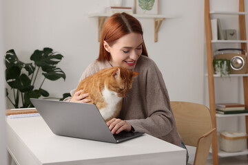 Happy woman with cat working at desk. Home office