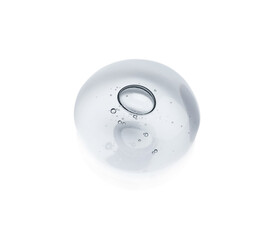 Drop of cosmetic oil on light surface, above view