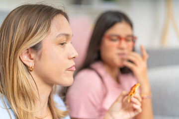 Close-up of women eating pizza at home