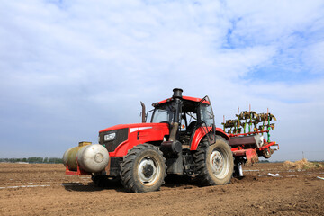 In spring, farmers use farm machinery to grow peanuts