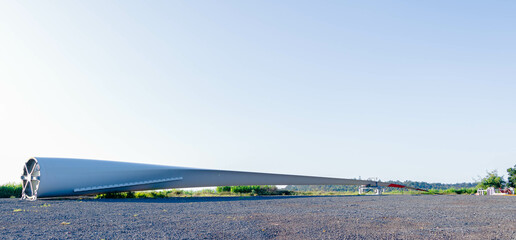 The wind turbine generate electricity, fan fields on the green grass over the blue clouded sky in...