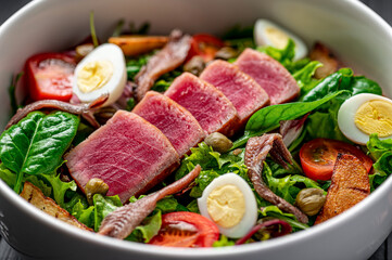 Salad Nisuaz with tuna, anchovies, potatoes, cherry tomatoes, salad mix, olive oil and quail egg
