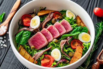 Salad Nisuaz with tuna, anchovies, potatoes, cherry tomatoes, salad mix, olive oil and quail egg