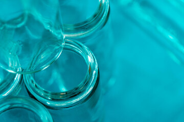 Empty glass jars with threaded rims and cool blue background