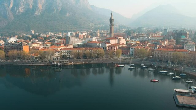Aerial beautiful morning cityscape of Lecco town and resort. Picturesque waterfront of Lecco town located between famous Lake Como and scenic Bergamo Alps mountains. Vacation destination in Italy.