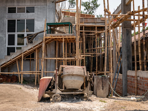 concrete mixer in front of a house under construction
