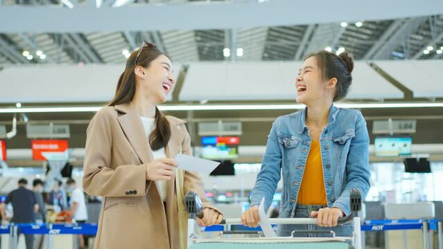 Asian young women passenger walk in airport terminal to boarding gate.