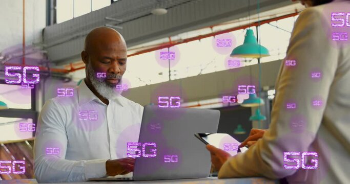 Animation of multiple 5g texts over diverse coworkers working on laptop and digital tablet