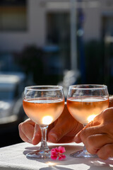 Pouring in glasses of cold rose Cote de Provence wine in yacht harbour of Port Grimaud, summer vacation on French Riviera Provence, France