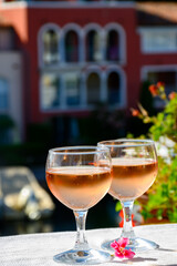 Pouring in glasses of cold rose Cote de Provence wine in yacht harbour of Port Grimaud, summer vacation on French Riviera Provence, France
