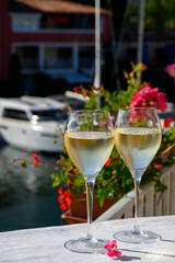 Glasses of cold white Cote de Provence wine in yacht harbour of Port Grimaud, summer vacation on French Riviera in Provence, France