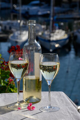 Glasses of cold white Cote de Provence wine in yacht harbour of Port Grimaud, summer vacation on French Riviera in Provence, France