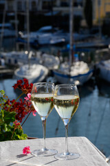 Glasses of cold white Cote de Provence wine in yacht harbour of Port Grimaud, summer vacation on French Riviera in Provence, France