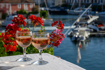 Pouring in glasses of cold rose Cote de Provence wine in yacht harbour of Port Grimaud, summer vacation on French Riviera Provence, France