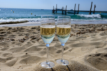 Summer time in Provence, two glasses of cold champagne cremant sparkling wine on famous Pampelonne sandy beach near Saint-Tropez in sunny day, Var department, France