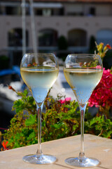 Drinking of French brut champagne sparkling wine in glasses, club party in yacht harbour of Port Grimaud near Saint-Tropez, French Riviera vacation, France