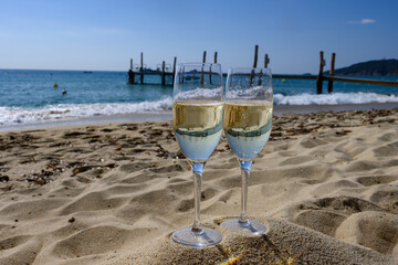 Summer time in Provence, two glasses of cold champagne cremant sparkling wine on famous Pampelonne...