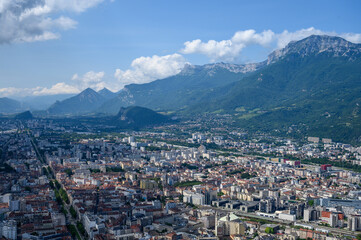 Fototapeta na wymiar View on central part of Grenoble city from Bastille fortres witn mountains around, old cable car, Isere, France