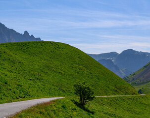 Narrow mountains road from Col de Lautaret to Col du Calibier, Mountains and alpine meadows views of Massif des Ecrins, Hautes Alpes, France in summer