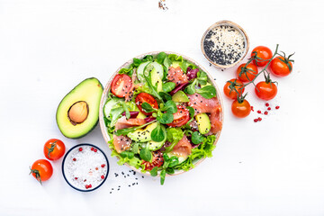 Keto salad with salted salmon, avocado, tomatoes, lettuce, cucumber, sesame seeds. Low-carbohydrate...