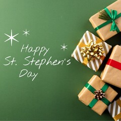 Composite of happy st stephen's day text and christmas presents on green background, copy space