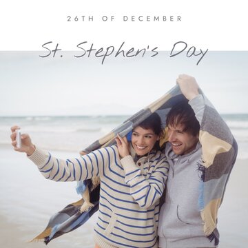 26th of december, st stephen's day text over caucasian couple taking selfie under scarf at beach