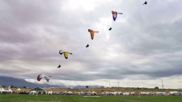 Paragliders Flying Over One Another Near Ground - Wide, Slow Motion Shot