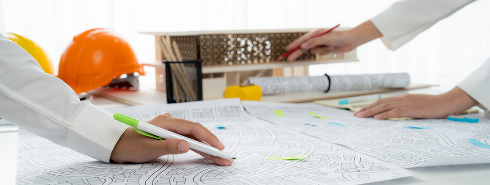 Worker, architect and engineer work on real estate construction project oratory planning with cartography and cadastral map of urban town area to guide to construction developer business plan of city