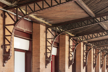 A wooden ceiling secured with vintage metal brackets to the brick walls