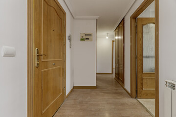 Hallway and hallway of a home with access to several rooms, built-in wardrobes and access door to the home with lock and armored hinges