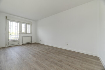Large empty bedroom of a single-family residential home with access to a terrace with a white...