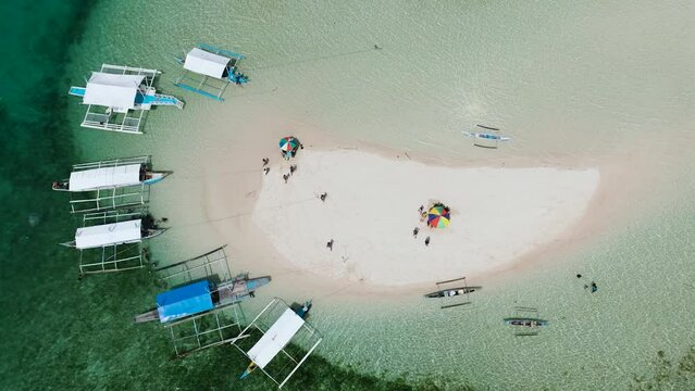 Drone view of boats on coastline of sandbar, turquoise water and colar reefs. Barobo, Surigao del Sur. Philippines.