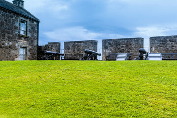 Cannons mounted on metal cart on rampart of castle.