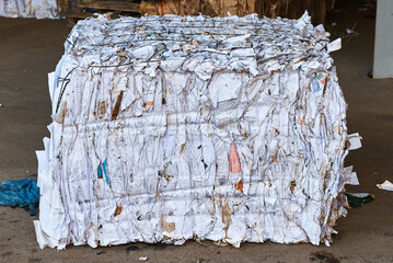 Pressed recycling paper on floor at waste processing plant