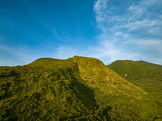 Mountain view with green hill and cliff under blue sky and clouds. Camiguin Island. Philippines.