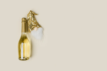 Champagne bottle and decor for bottle of wine, golden sequins hat of dwarf, Christmas and New Year holidays, festive background, copy space. Minimal style trend, beige golden colors
