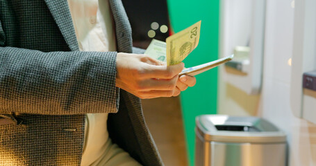 Woman hands with USD dollar near atm machine at night. Girl withdrawing money