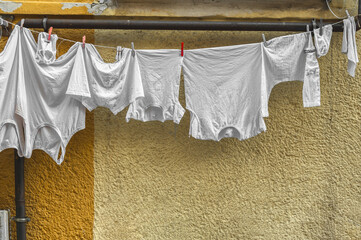 Freshly laundered linen hangs on a line on the front of the house. Ordinary life in the city.