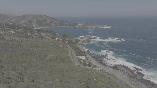 Plano a&eacute;reo desde drone de mar picado con olas chocando contra rocas en la costa. Zapallar, Chile. d-log 60 fps.