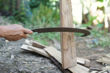 Close up man use hand saw to cut wood. Concept, carpentry tool and construction woodwork, Handmade diy craft with wood.                  