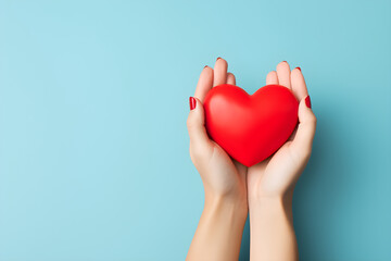 hands holding red heart isolated on blue background with copy space