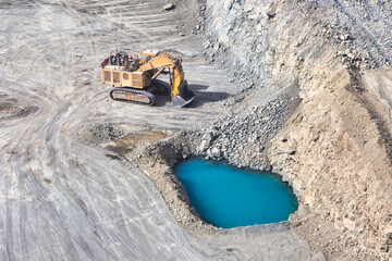 open pit diamond mine, Surface mining hydraulic excavator dinging in the pit, surface water...